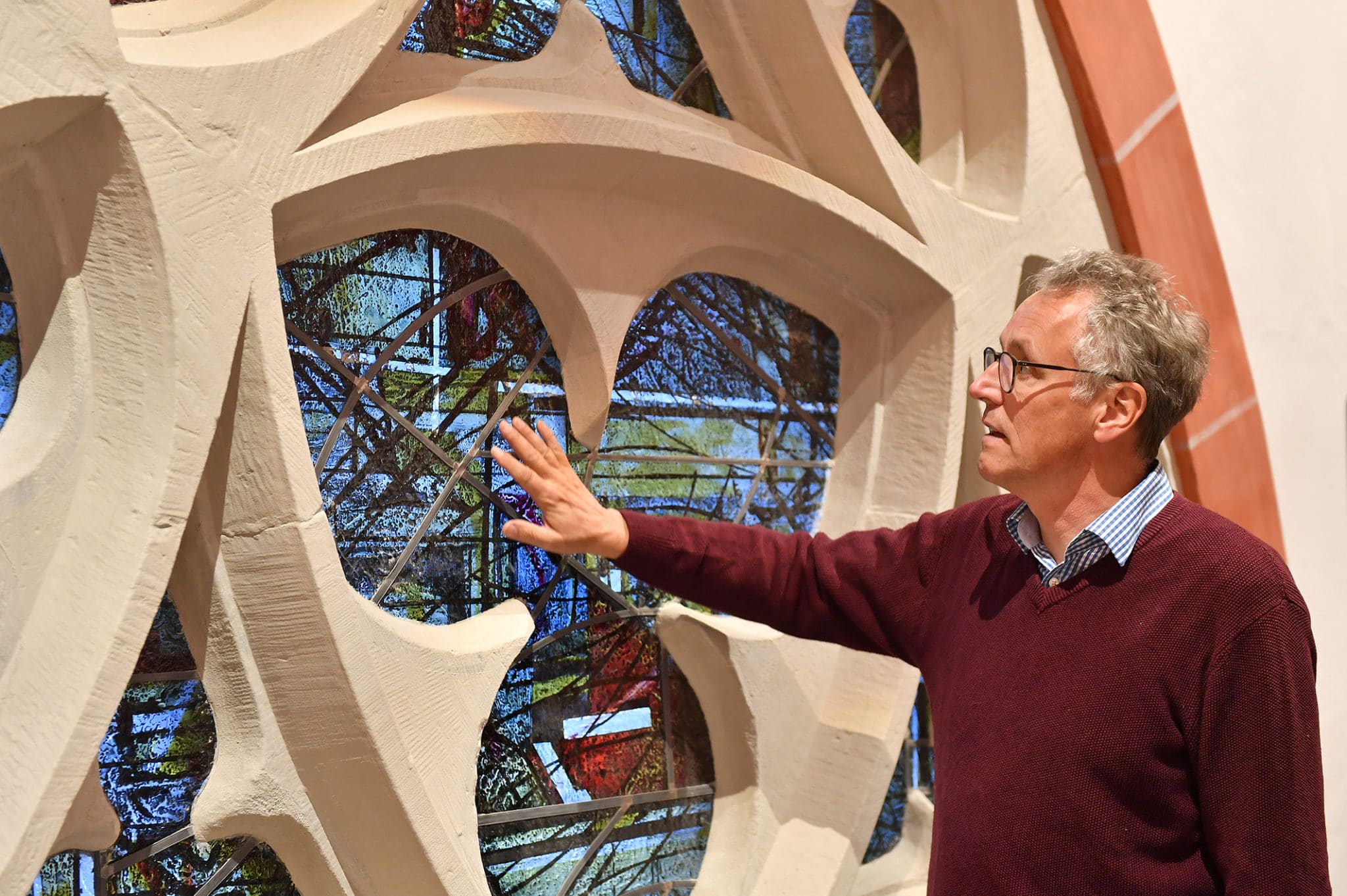 Pastor Gerhard Schridde an einem neugestalteten Kirchenfenster.